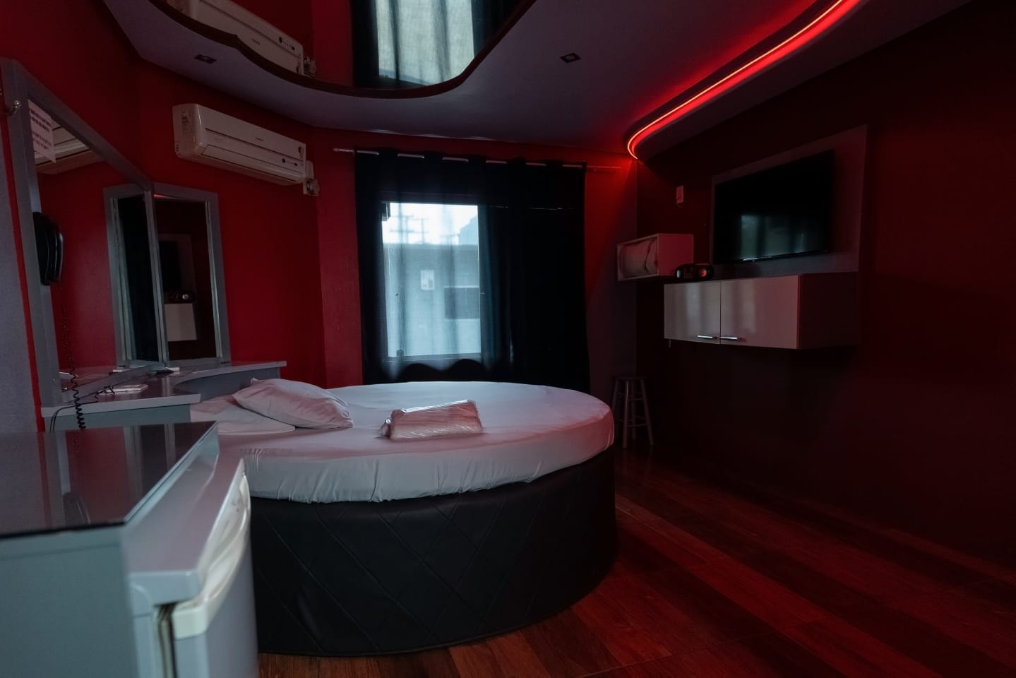 Suíte do Motel Lyon com cama redonda e iluminação vermelha